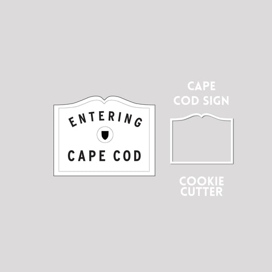 Cape cod sign next to a cape cod sign cookie cutter outline on a gray background.