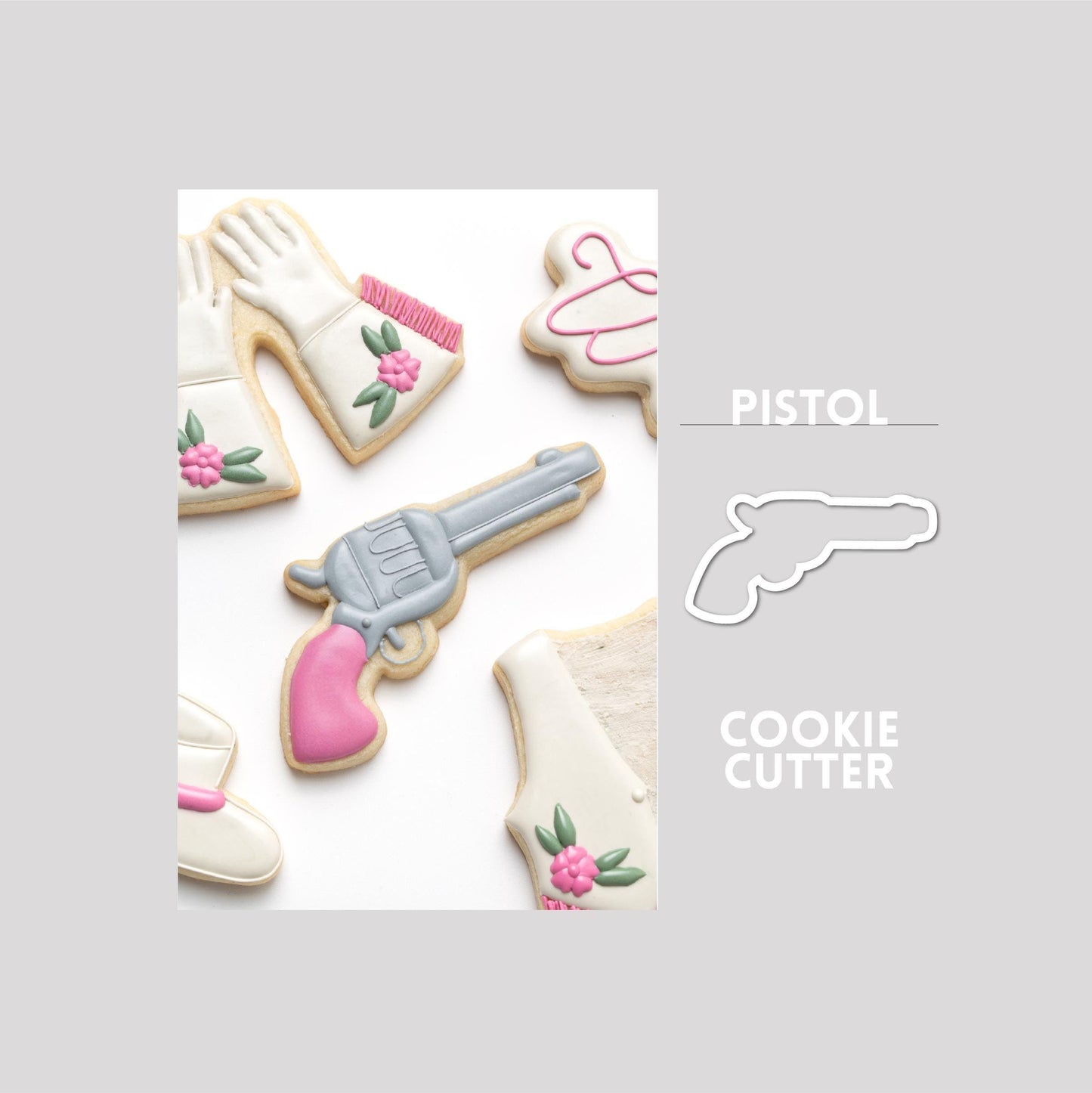 Decorated pistol sugar cookie next to a pistol cookie cutter outline on a gray background.