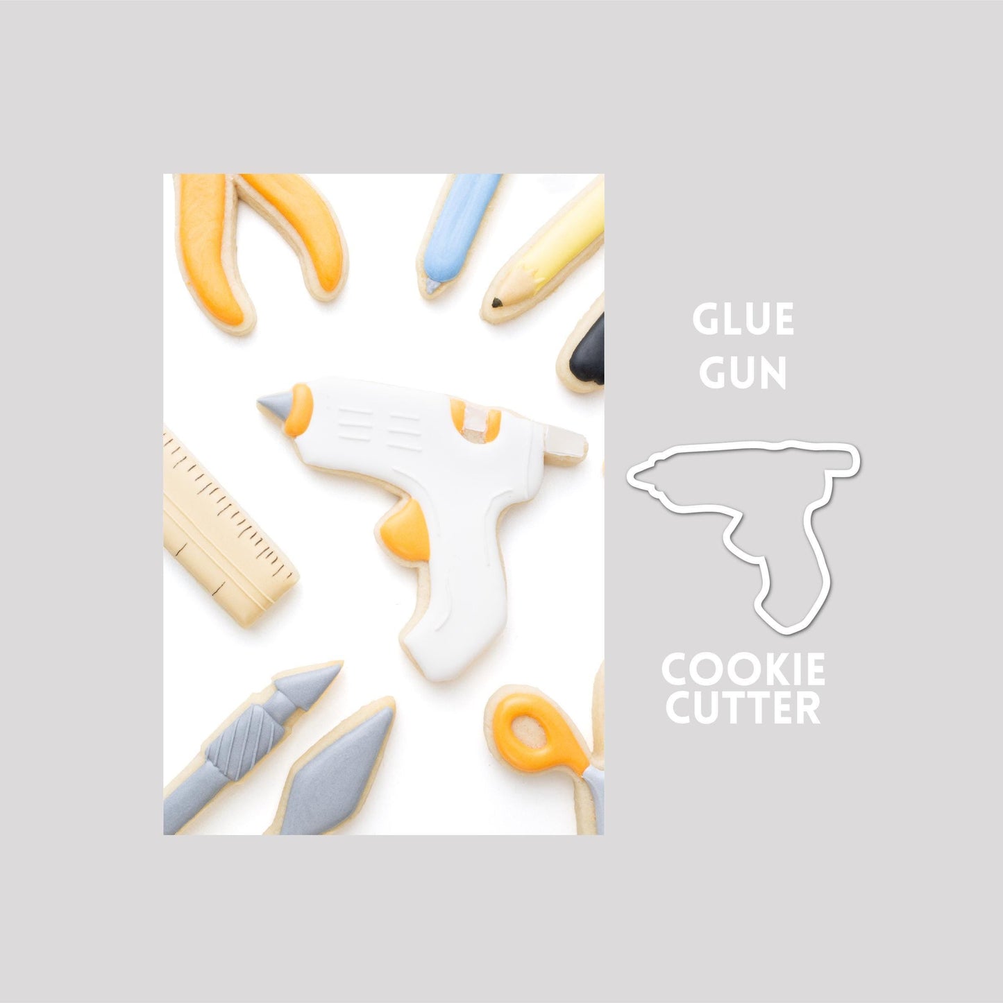 Decorated glue gun sugar cookie next to a glue gun cookie cutter outline on a gray background.