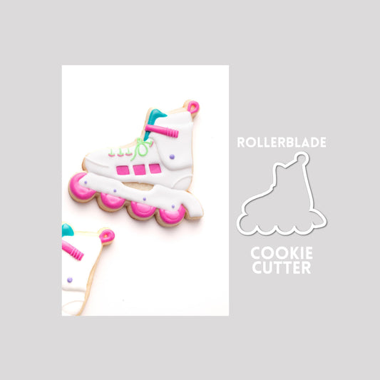 Decorated rollerblade sugar cookie next to a rollerblade cookie cutter outline on a gray background.