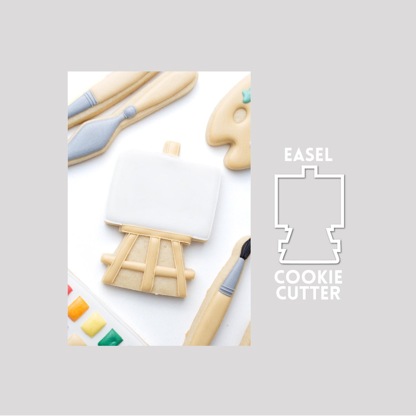 Decorated pain teasel sugar cookie next to a easel cookie cutter outline on a gray background.