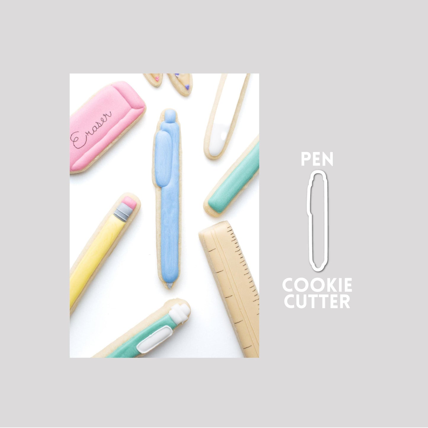 Decorated pen sugar cookie next to a pen cookie cutter outline on a gray background.