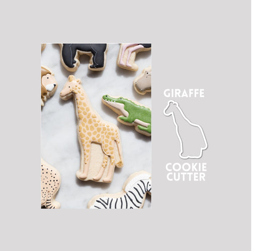 Decorated giraffe sugar cookie next to a giraffe cookie cutter outline on a gray background.