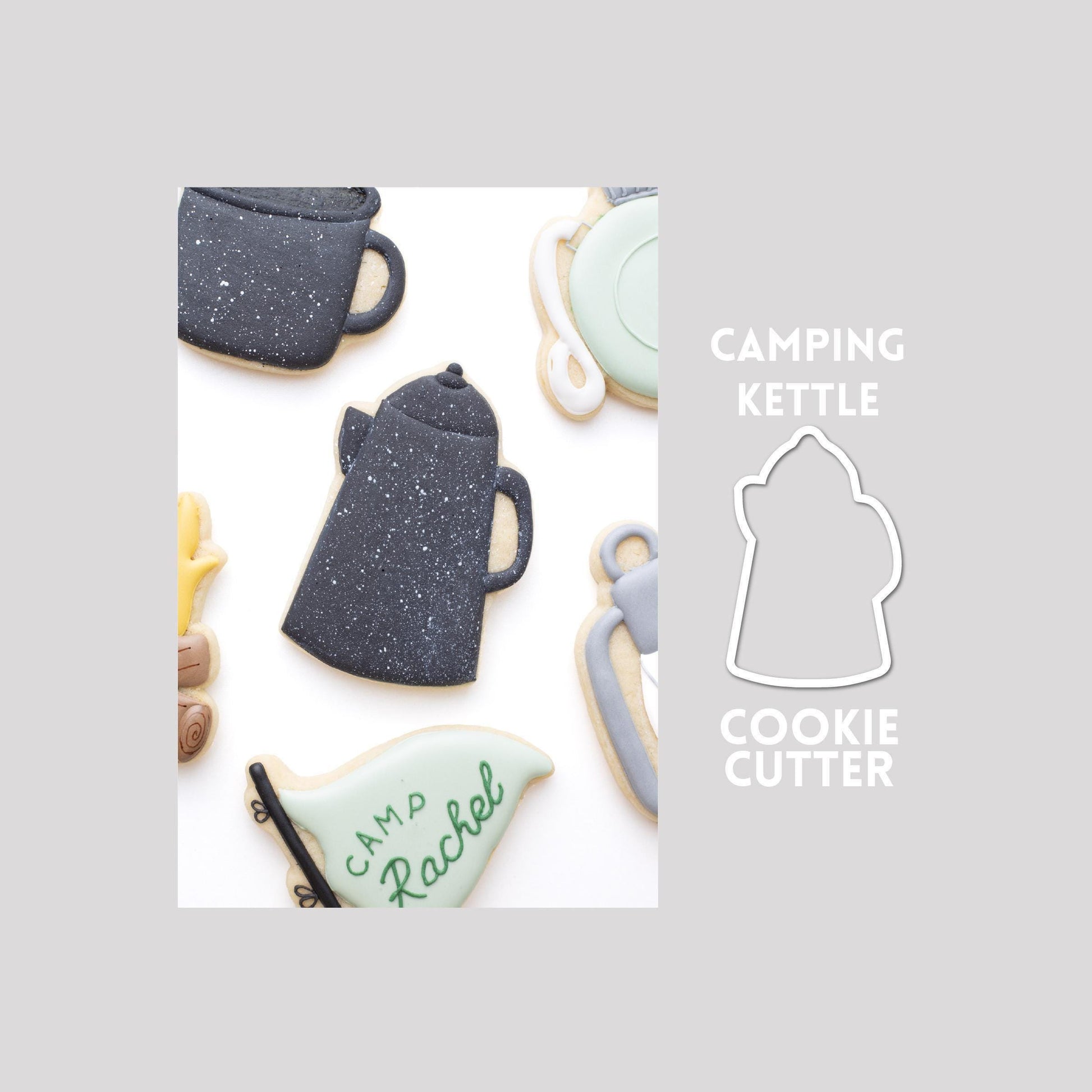 Decorated camping kettle sugar cookie next to a camping kettle cookie cutter outline on a gray background.