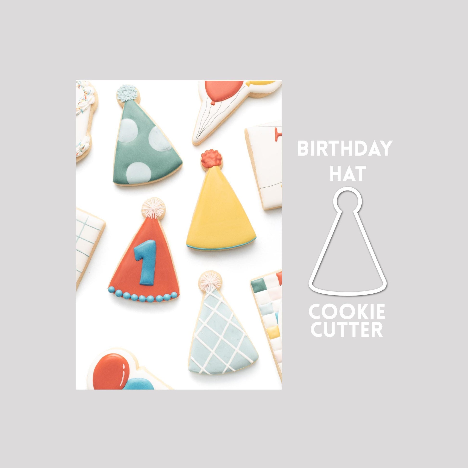 Decorated birthday hat sugar cookie next to a birthday hat cookie cutter outline on a gray background.