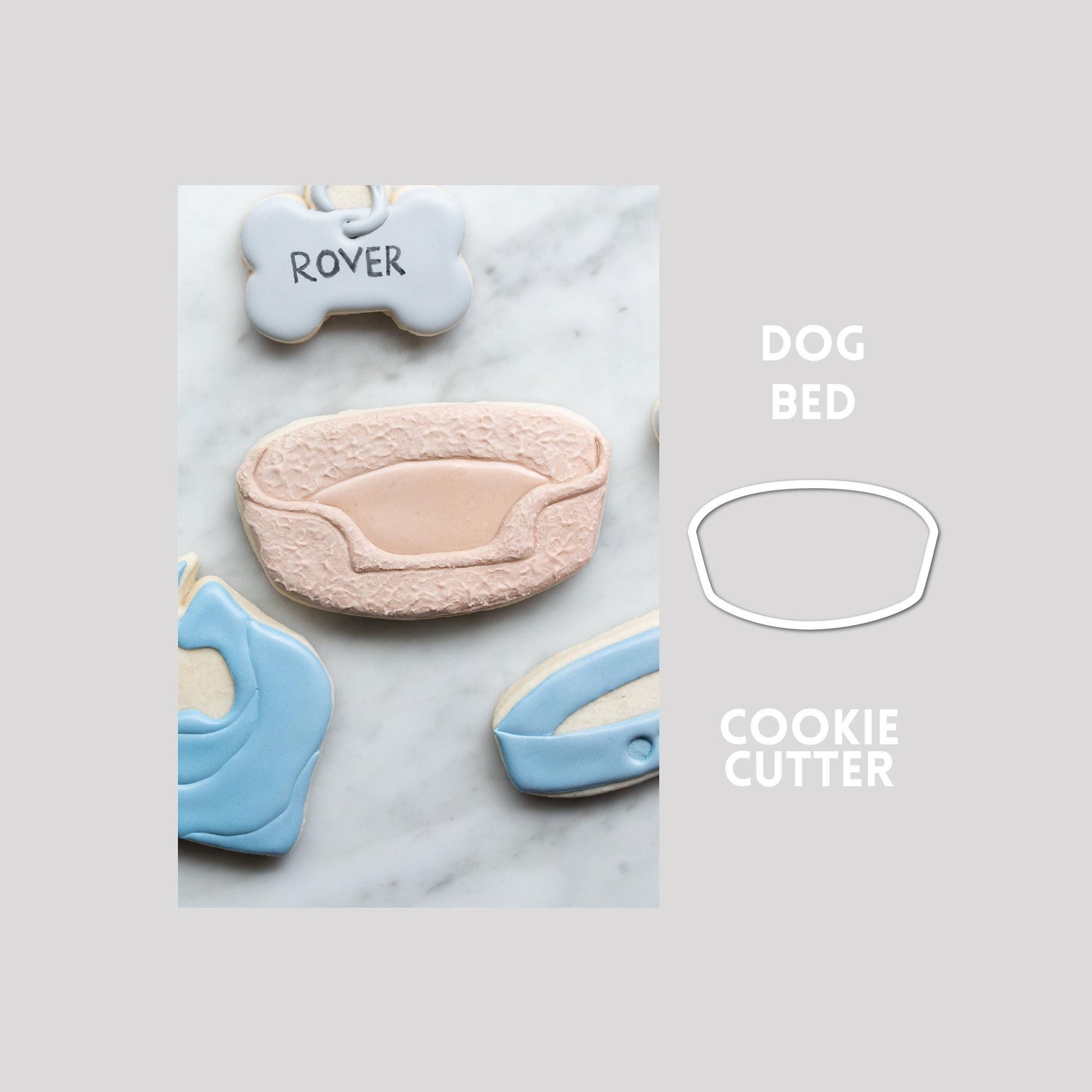 Decorated dog bed sugar cookie next to a dog bed cookie cutter outline on a gray background.
