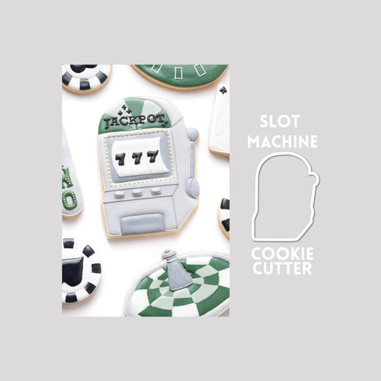 Decorated slot machine sugar cookie next to a slot machine cookie cutter outline on a gray background.