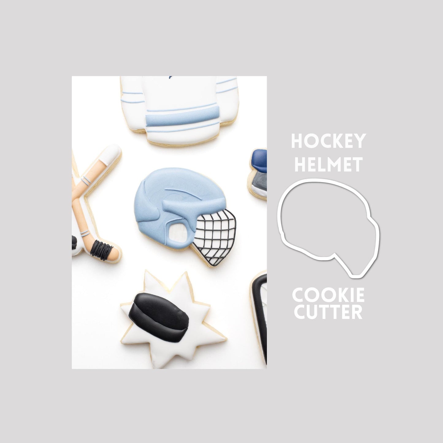 Decorated hockey helmet sugar cookie next to a hockey helmet cookie cutter outline on a gray background.