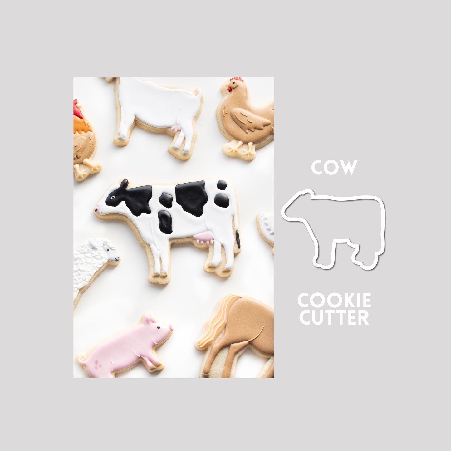 Decorated cow sugar cookie next to a cow cookie cutter outline on a gray background.