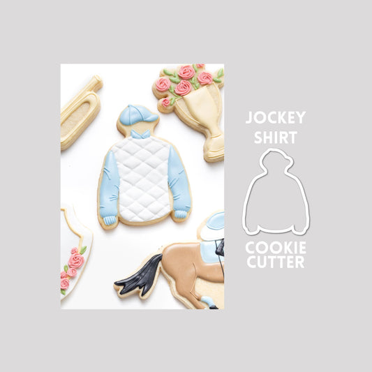Decorated jockey shirt sugar cookie next to a jockey shirt cookie cutter outline on a gray background.