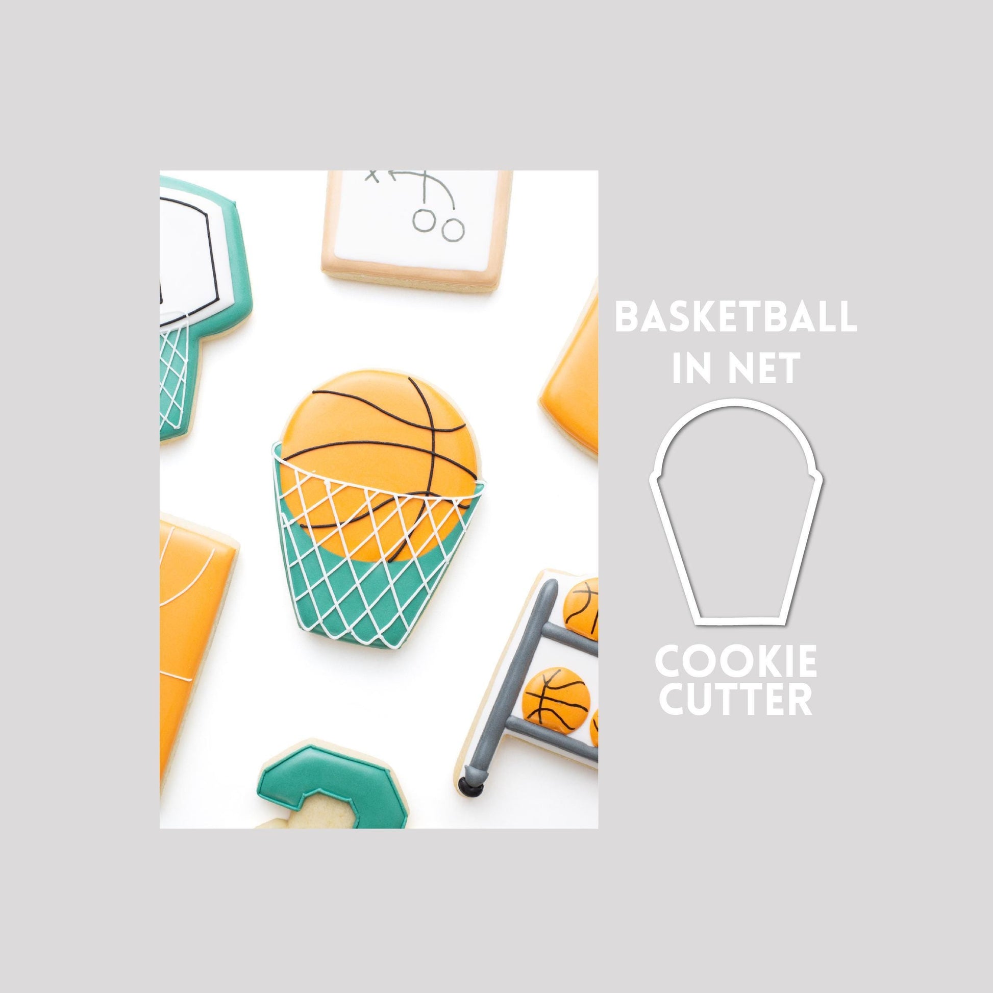 Decorated basketball in net sugar cookie next to a basketball in net cookie cutter outline on a gray background.