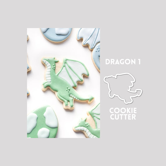 Decorated dragon sugar cookie next to a dragon cookie cutter outline on a gray background.