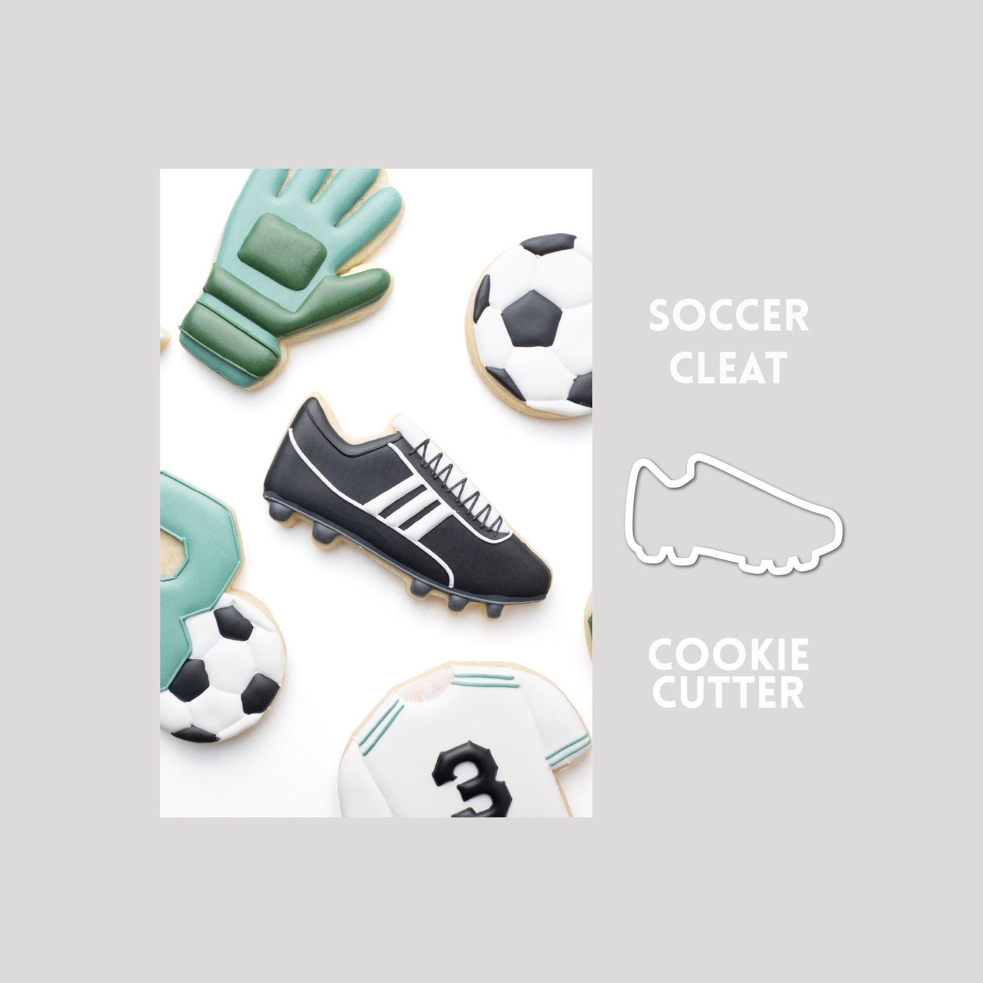 Decorated soccer cleat sugar cookie next to a soccer cleat cookie cutter outline on a gray background.