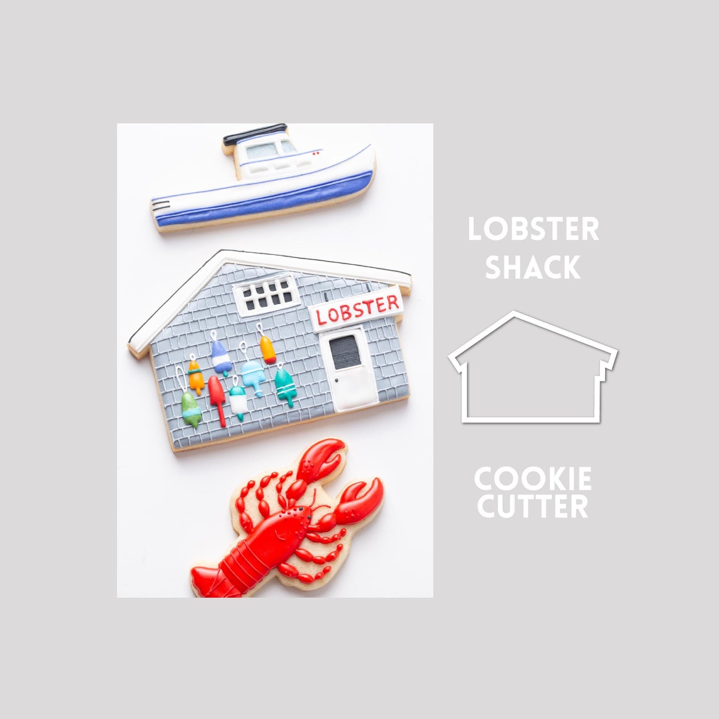 Decorated lobster shack sugar cookie next to a lobster shack cookie cutter outline on a gray background.