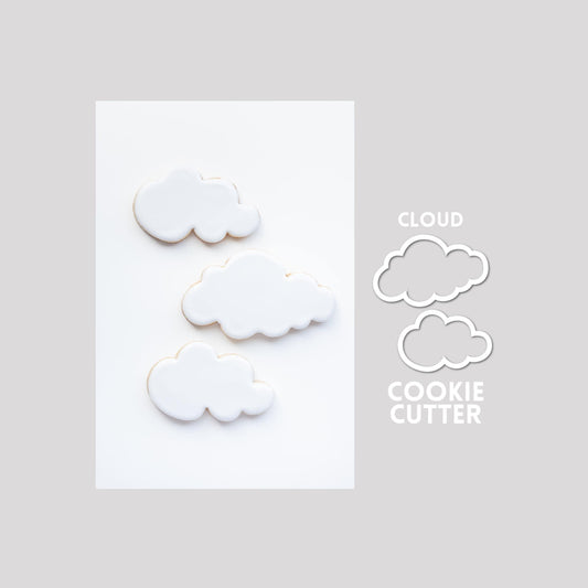 Decorated cloud sugar cookies next to a cloud cookie cutter outline on a gray background.