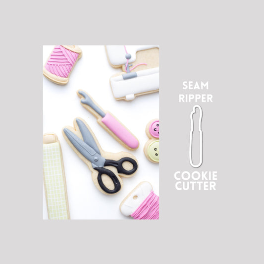 Decorated seam ripper sugar cookie next to a seam ripper cookie cutter outline on a gray background.