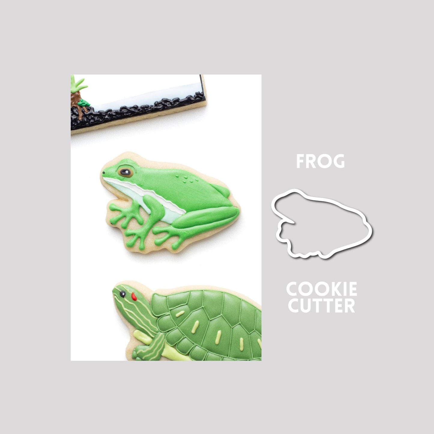 Decorated frog sugar cookie next to a frog cookie cutter outline on a gray background.