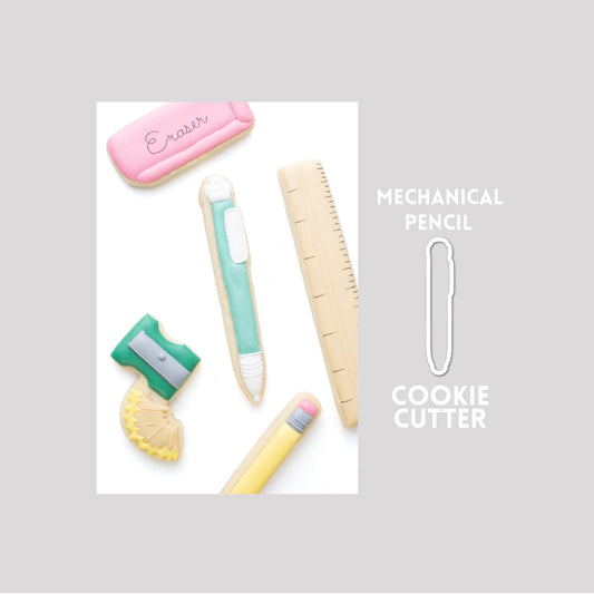 Decorated mechanical pencil sugar cookie next to a mechanical pencil cookie cutter outline on a gray background.