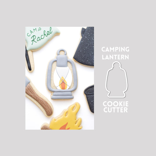Decorated lantern sugar cookie next to a lantern cookie cutter outline on a gray background.