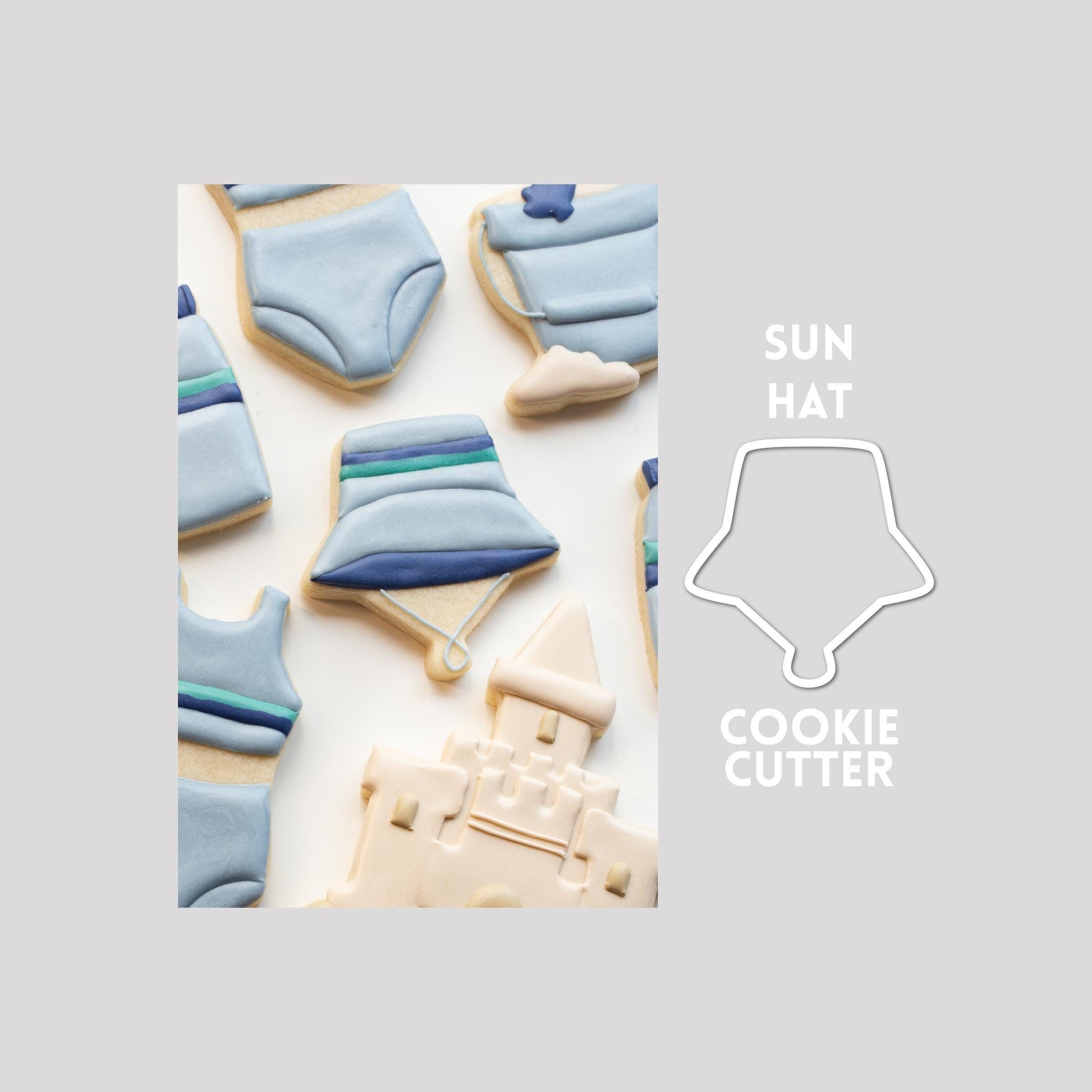 Decorated bucket hat sugar cookie next to a bucket hat cookie cutter outline on a gray background.
