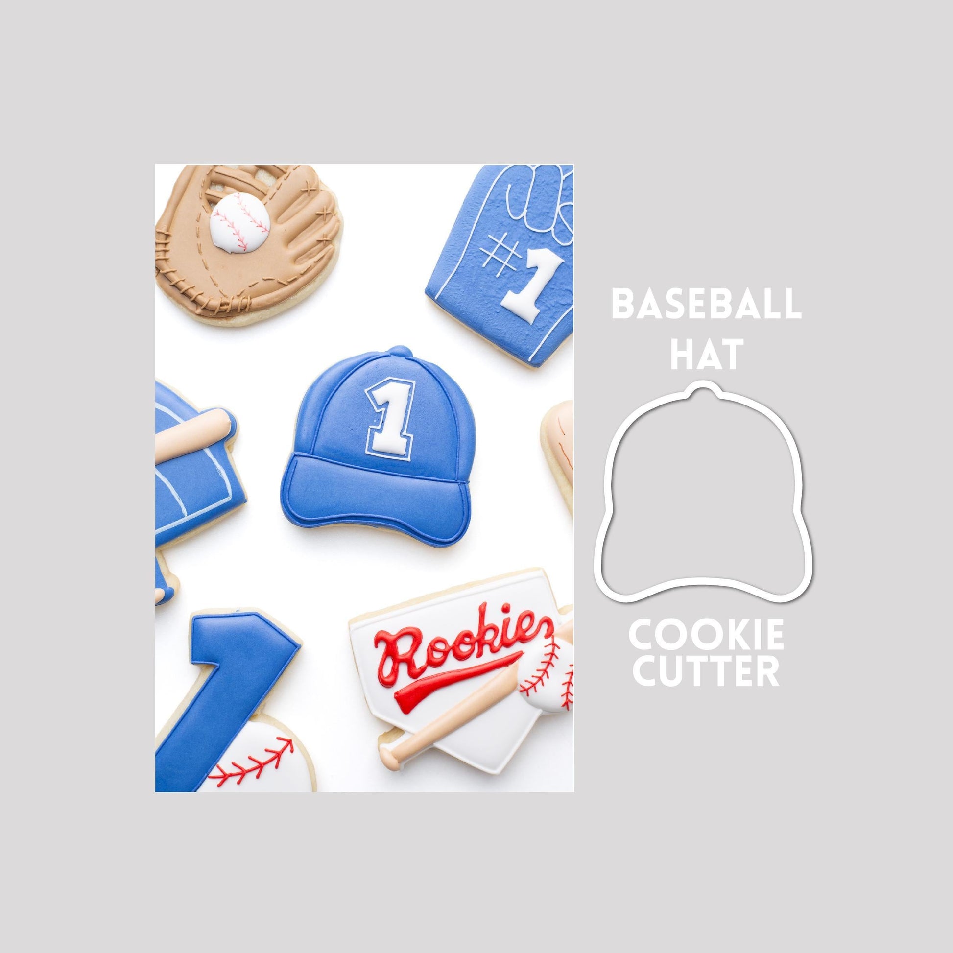 Decorated baseball hat sugar cookie next to a baseball hat cookie cutter outline on a gray background.
