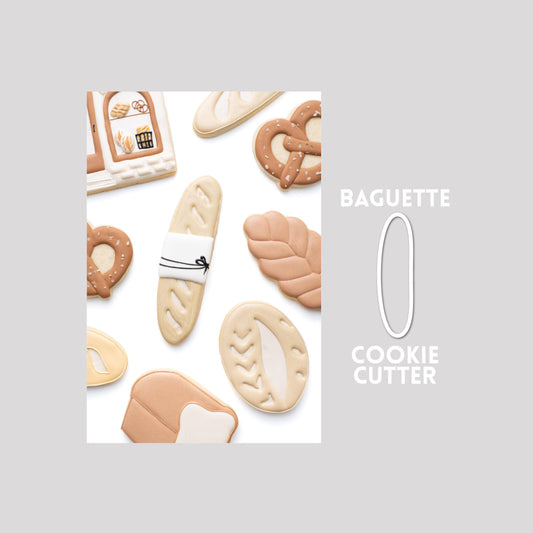 Decorated baguette sugar cookie next to a baguette cookie cutter outline on a gray background.