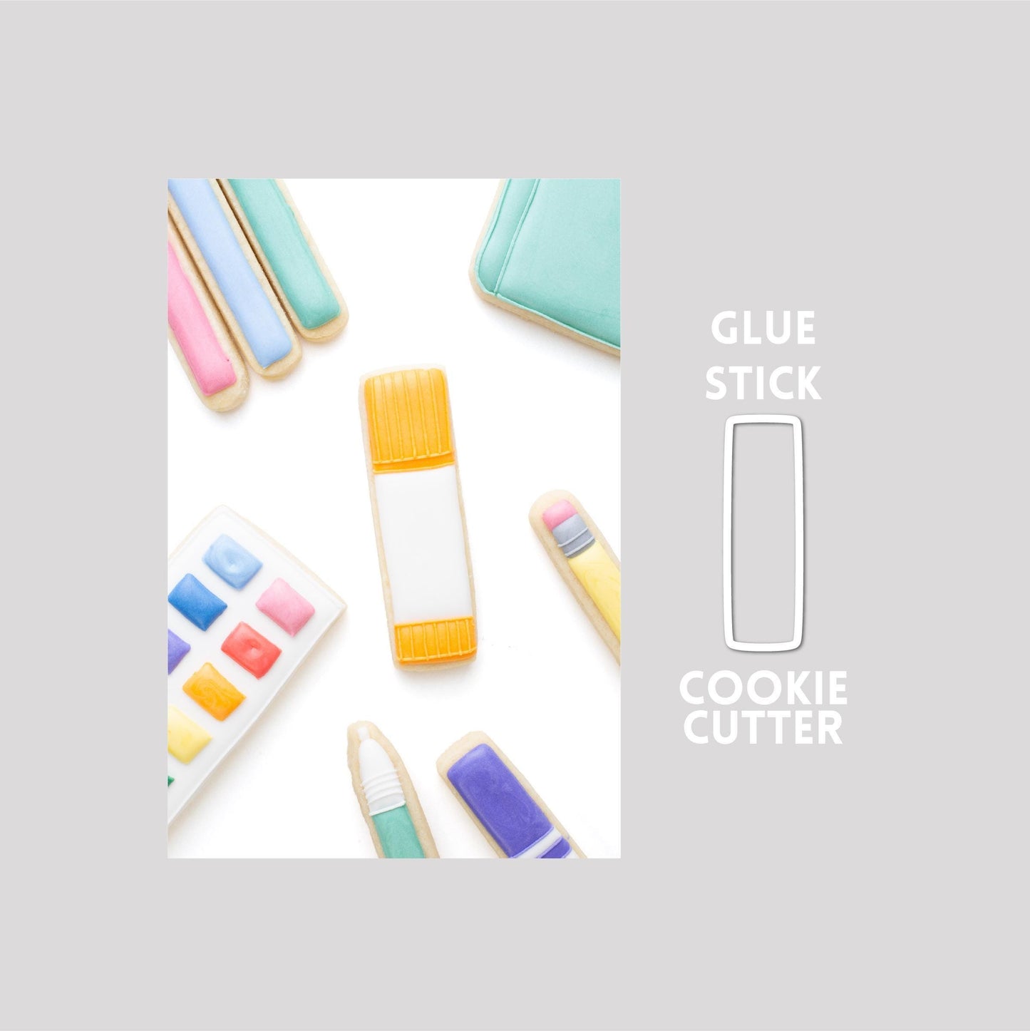 Decorated glue stick sugar cookie next to a glue stick cookie cutter outline on a gray background.