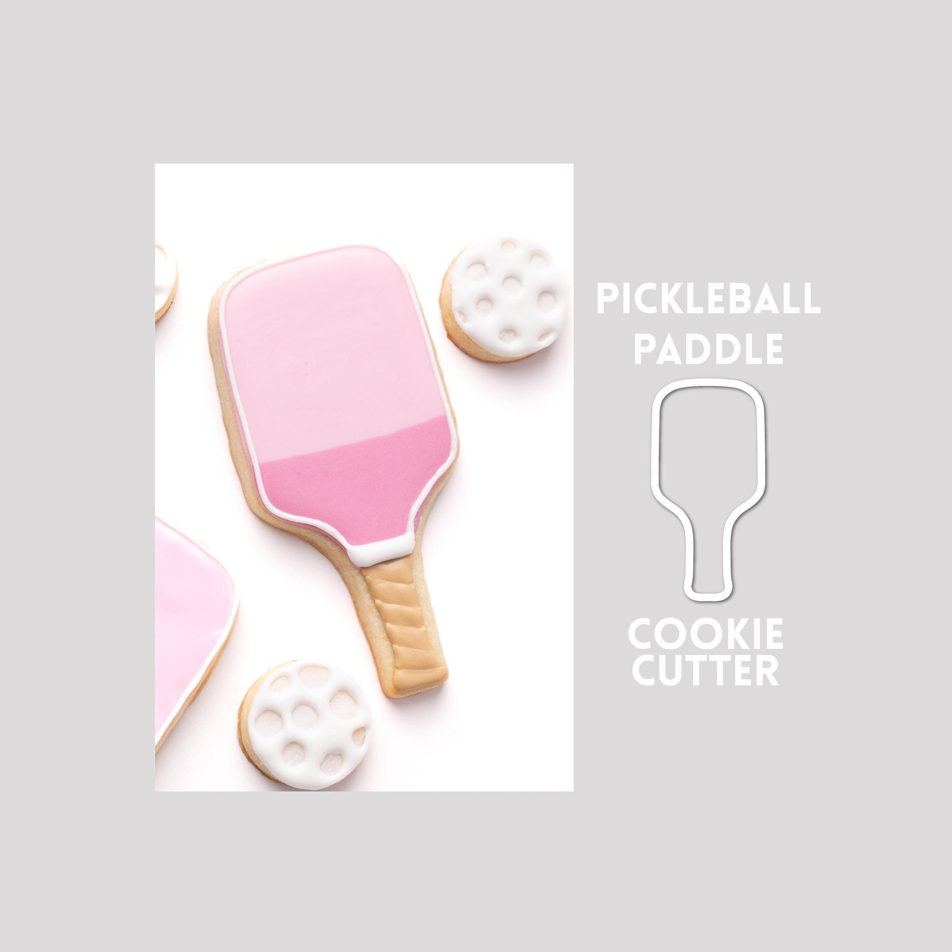 Decorated pickleball sugar cookie next to a pickleball cookie cutter outline on a gray background.