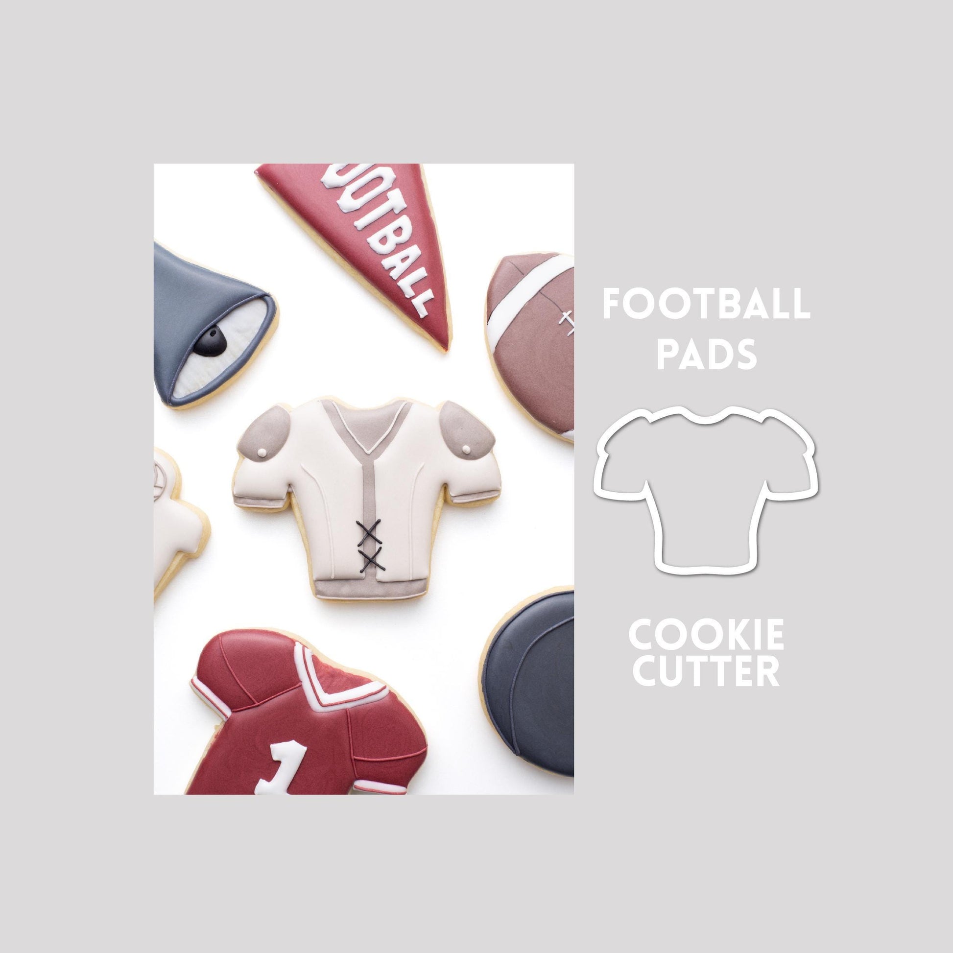 Decorated football pads sugar cookie next to a football pads cookie cutter outline on a gray background.