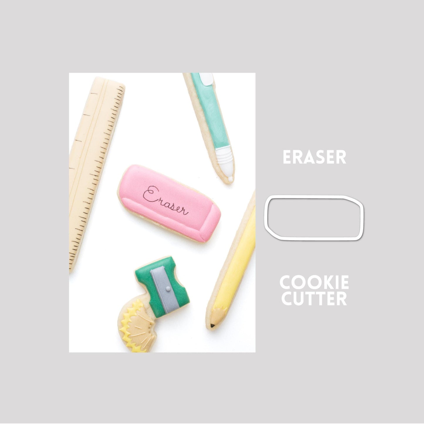 Decorated eraser sugar cookie next to a eraser cookie cutter outline on a gray background.
