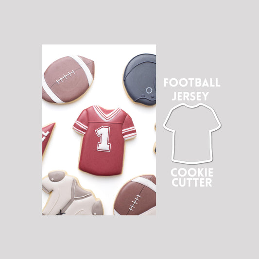 Decorated football jersey sugar cookie next to a football jersey cookie cutter outline on a gray background.