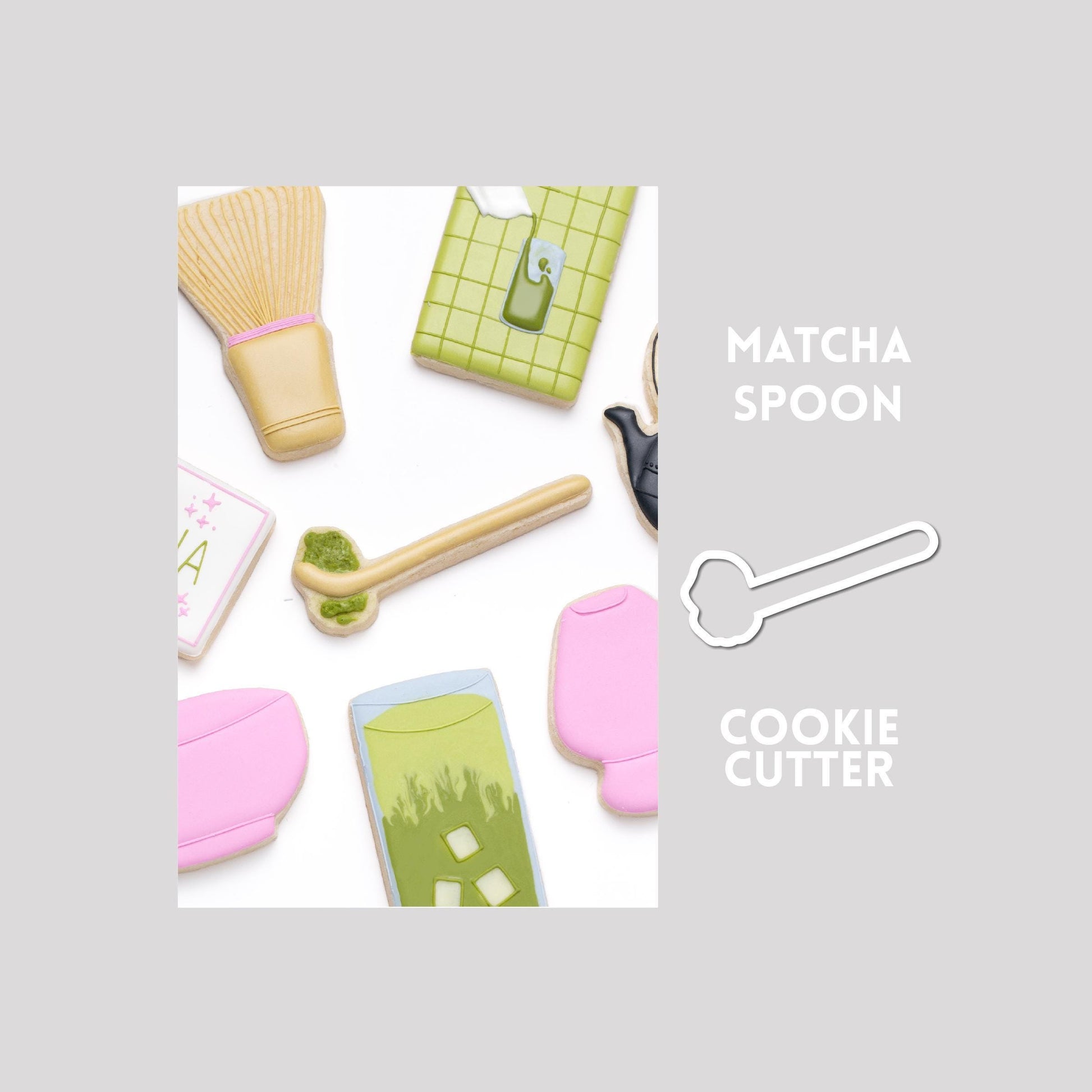 Decorated matcha spoon sugar cookie next to a matcha spoon cookie cutter outline on a gray background.