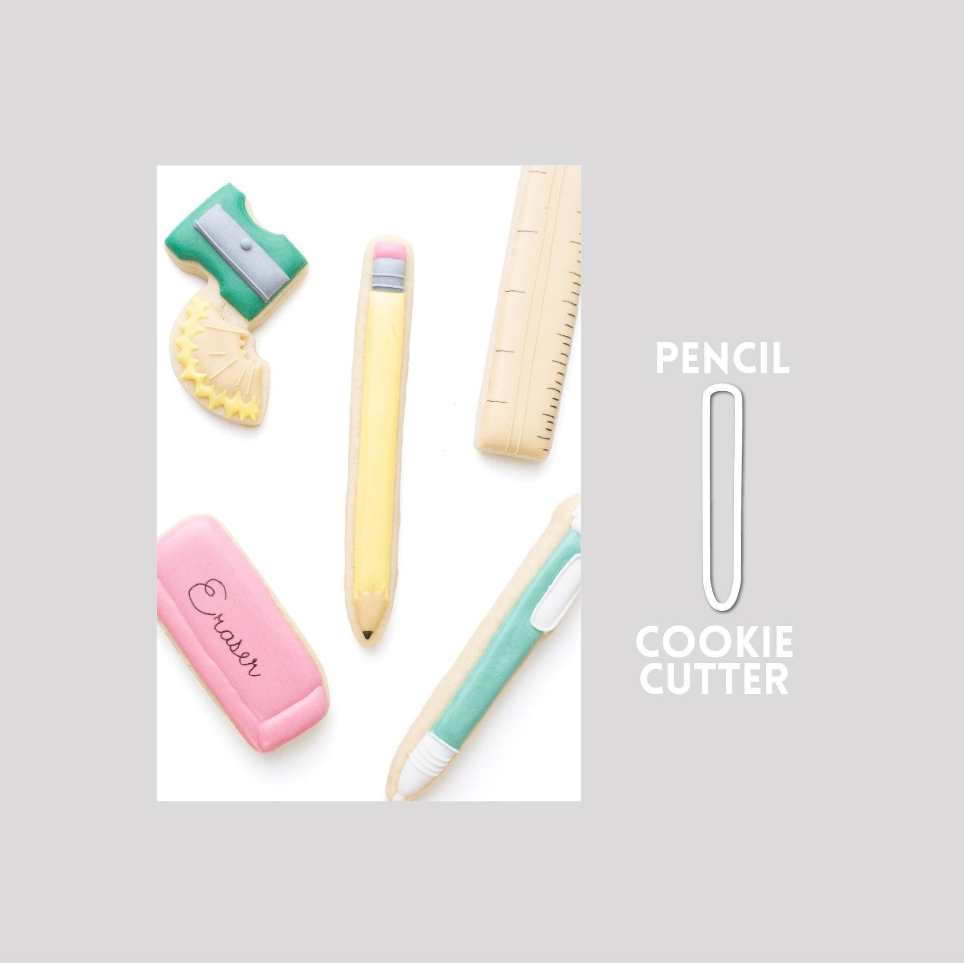 Decorated pencil sugar cookie next to a pencil cookie cutter outline on a gray background.