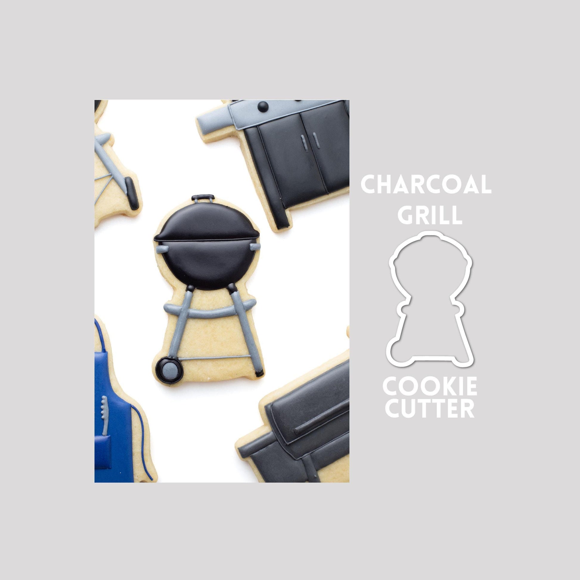 Decorated charcoal grill sugar cookie next to a charcoal grill cookie cutter outline on a gray background.