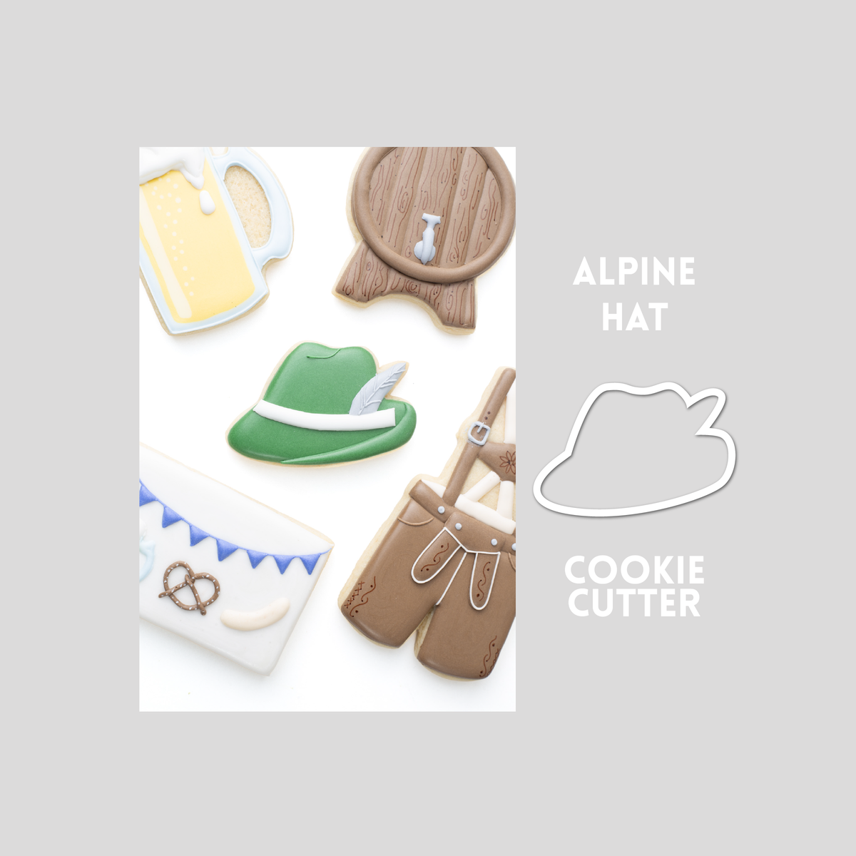 Decorated Alpine Hat sugar cookie next to a Alpine Hat cookie cutter outline on a gray background.