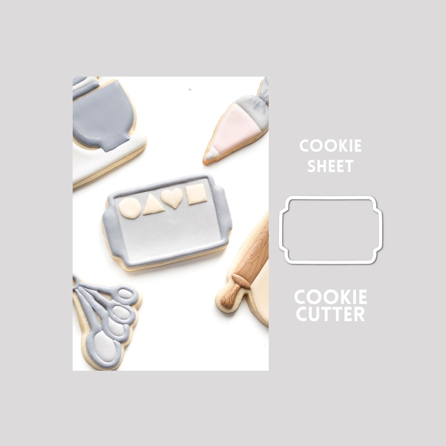 Decorated cookie sheet sugar cookie next to a cookie sheet cookie cutter outline on a gray background.