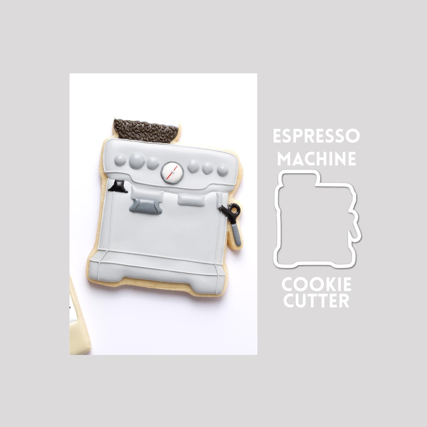 Decorated espresso machine sugar cookie next to a espresso machine cookie cutter outline on a gray background.
