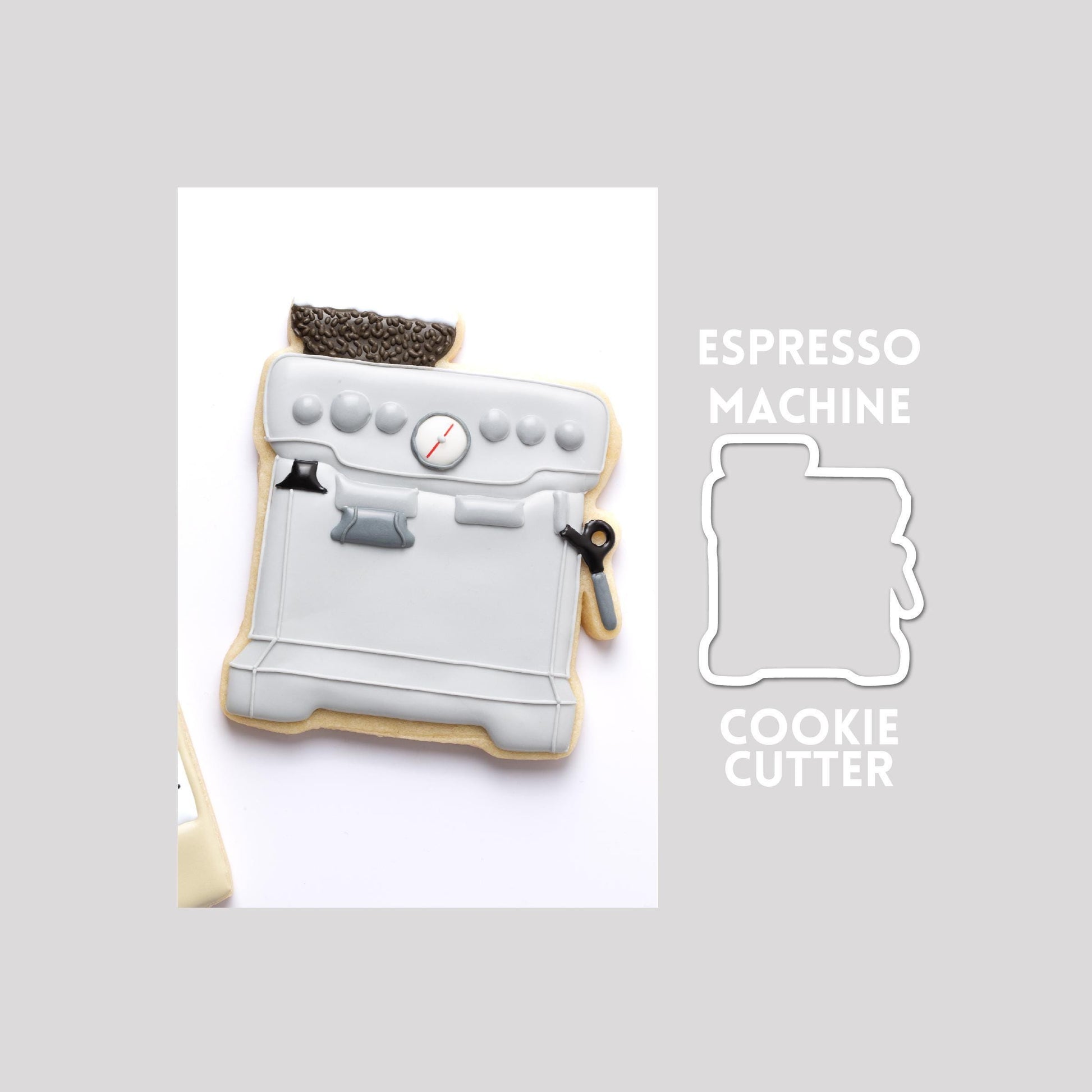 Decorated espresso machine sugar cookie next to a espresso machine cookie cutter outline on a gray background.