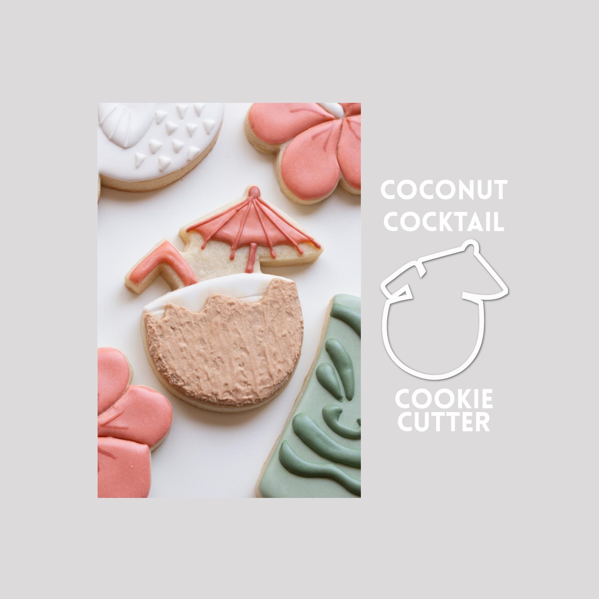 Decorated coconut cocktail sugar cookie next to a coconut cocktail cookie cutter outline on a gray background.
