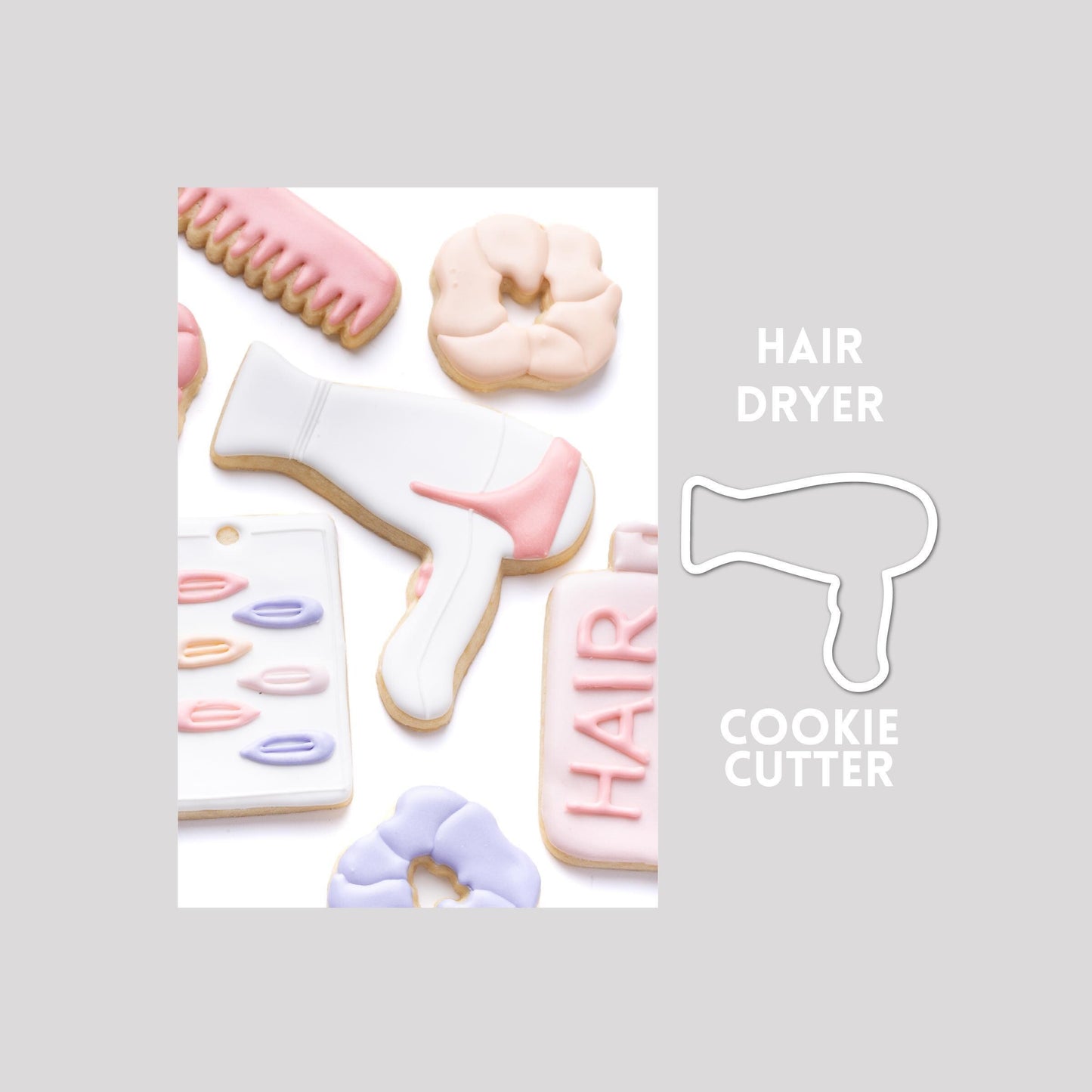 Decorated hair dryer sugar cookie next to a hair dryer cookie cutter outline on a gray background.
