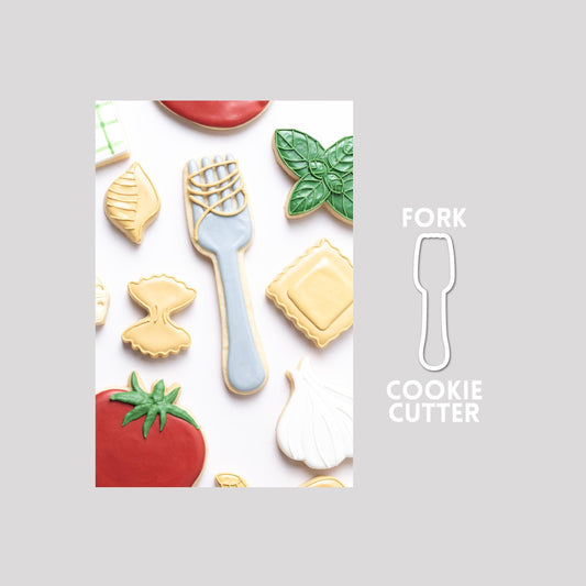 Decorated fork sugar cookie next to a fork cookie cutter outline on a gray background.