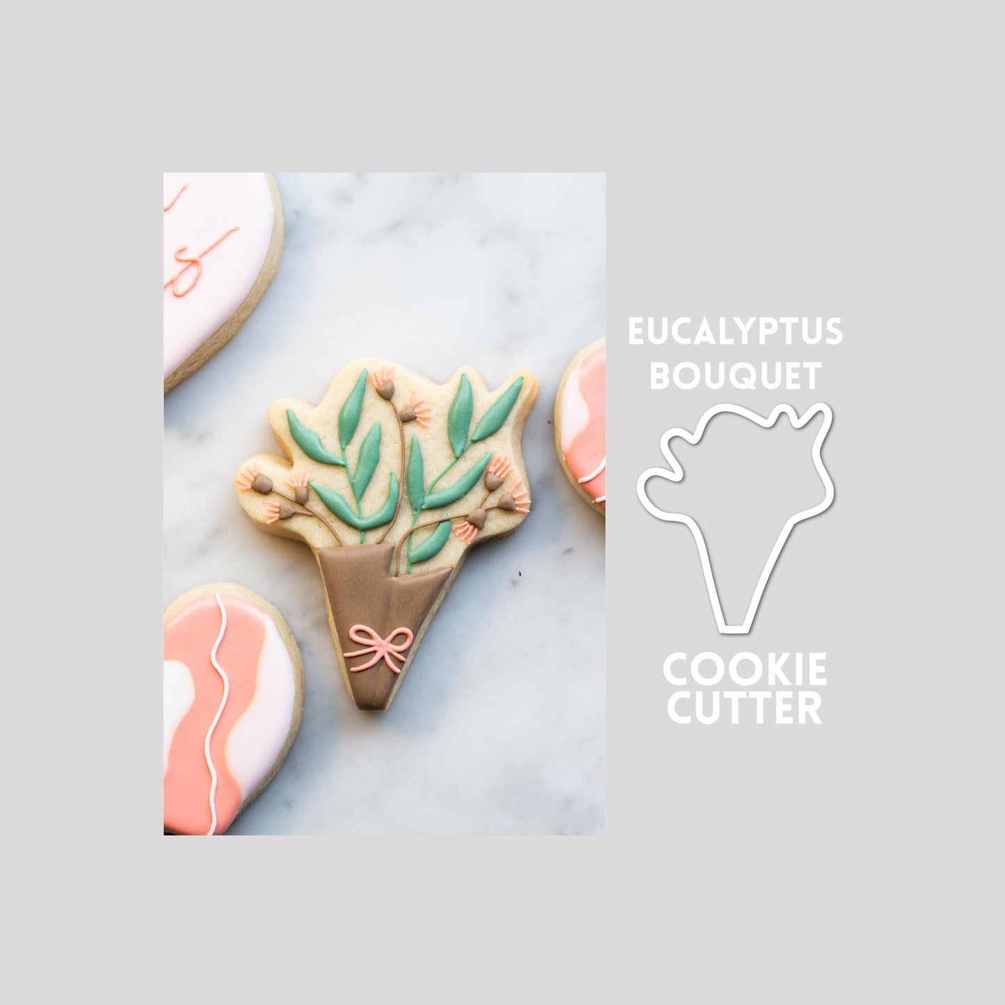 Decorated eucalyptus bouquet sugar cookie next to a eucalyptus bouquet cookie cutter outline on a gray background.