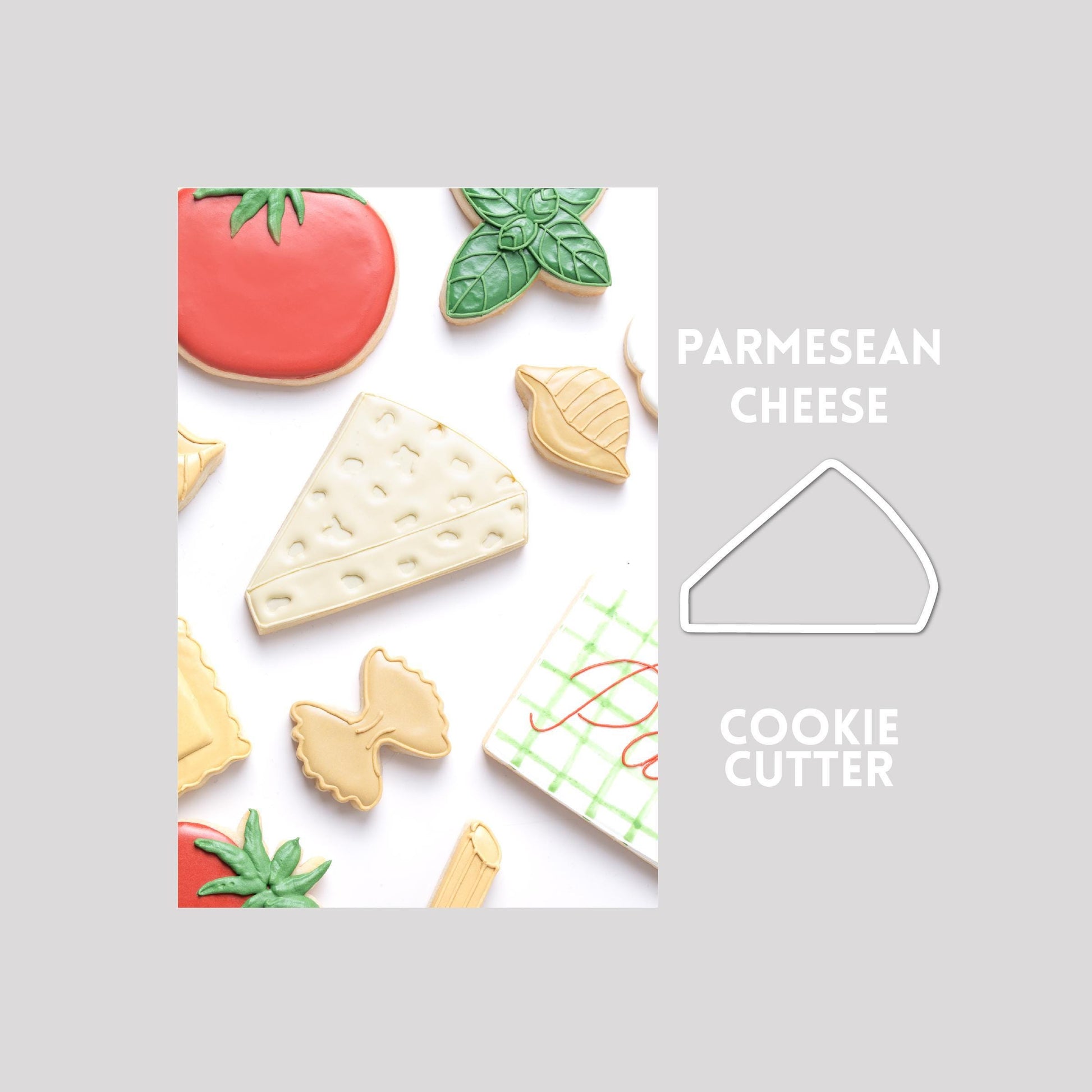 Decorated parmesan cheese sugar cookie next to a parmesan cheese cookie cutter outline on a gray background.
