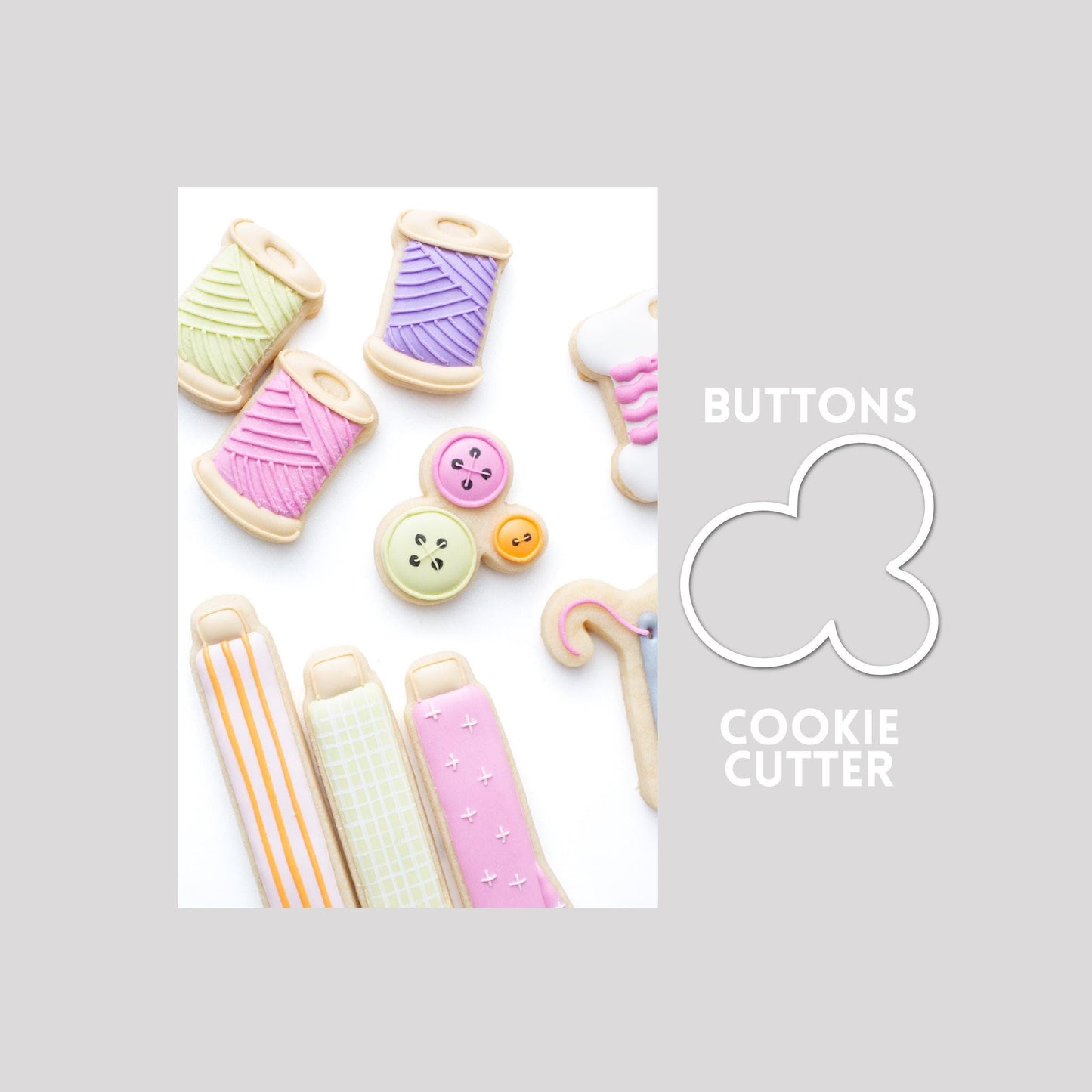Decorated buttons sugar cookie next to a buttons cookie cutter outline on a gray background.
