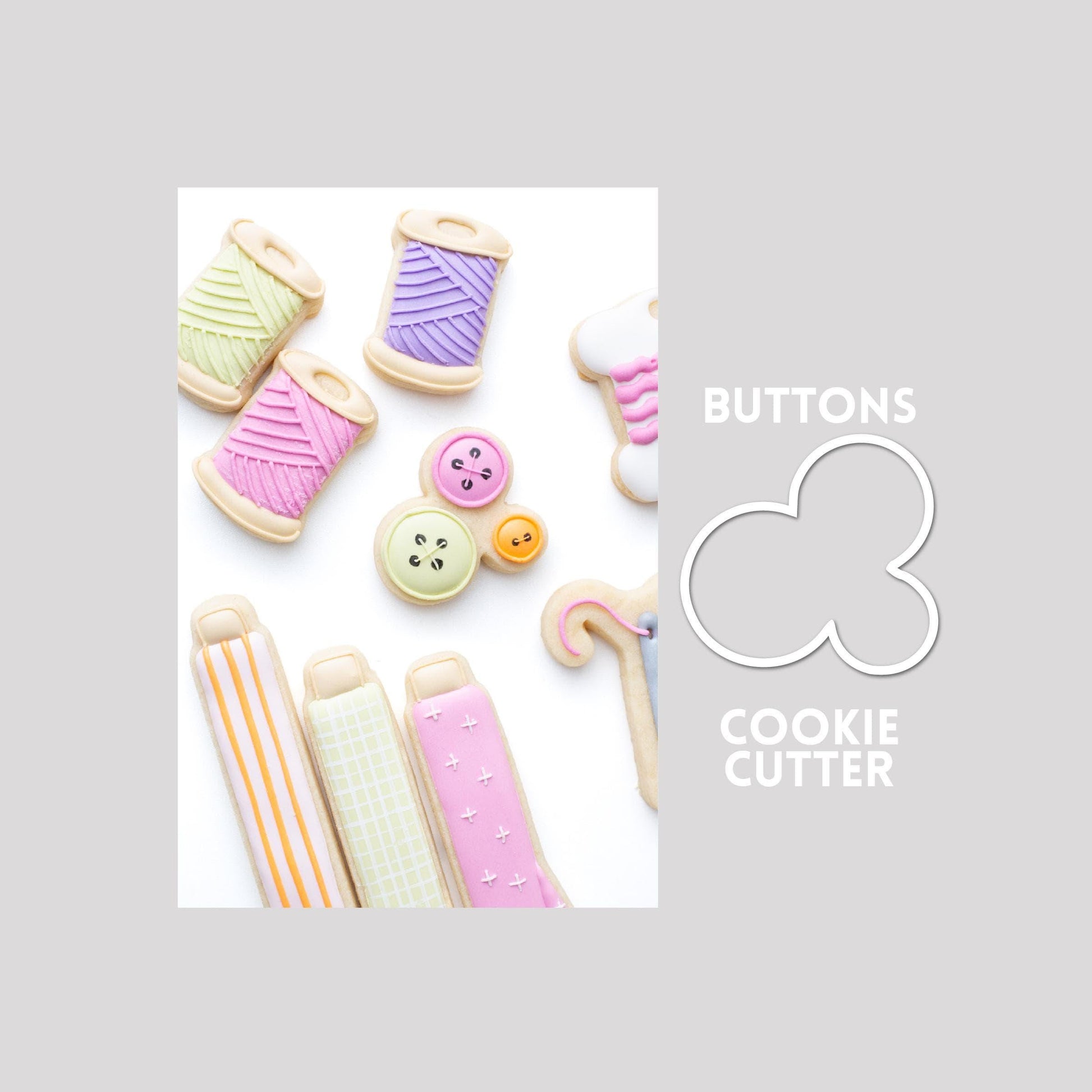 Decorated buttons sugar cookie next to a buttons cookie cutter outline on a gray background.