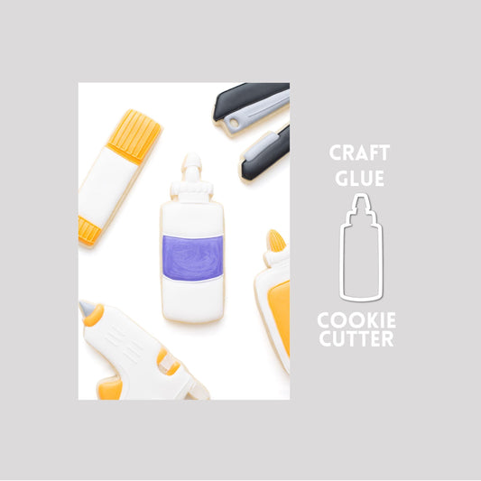 Decorated craft glue sugar cookie next to a craft glue cookie cutter outline on a gray background.