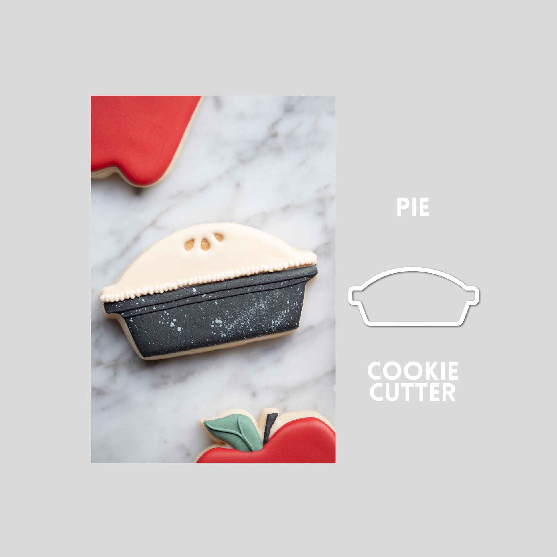 Decorated pie sugar cookie next to a pie cookie cutter outline on a gray background.