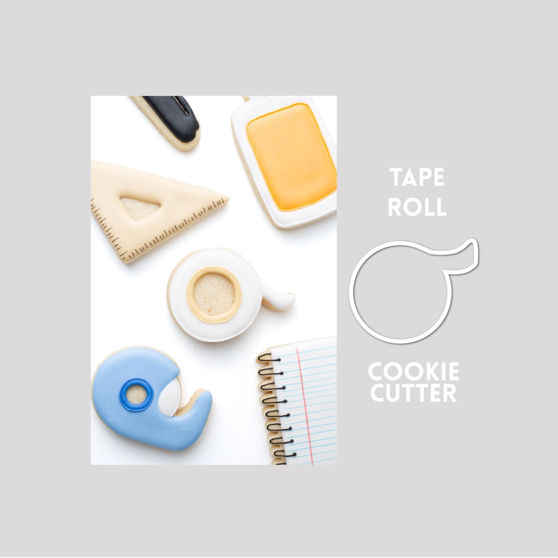 Decorated tape roll sugar cookie next to a tape roll cookie cutter outline on a gray background.