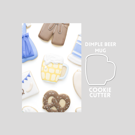 Decorated dimple beer mug sugar cookie next to a dimple beer mug cookie cutter outline on a gray background.
