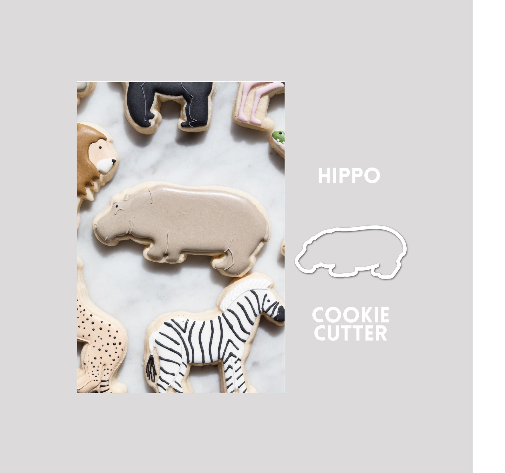 Decorated hippo sugar cookie next to a hippo cookie cutter outline on a gray background.